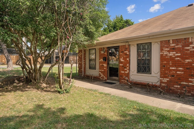 property entrance with a lawn