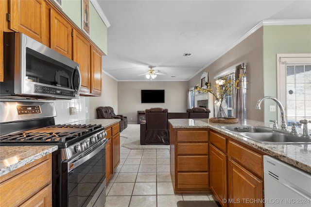 kitchen featuring sink, ceiling fan, light tile patterned floors, ornamental molding, and appliances with stainless steel finishes