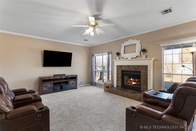 carpeted living room featuring a brick fireplace, crown molding, ceiling fan, and a healthy amount of sunlight