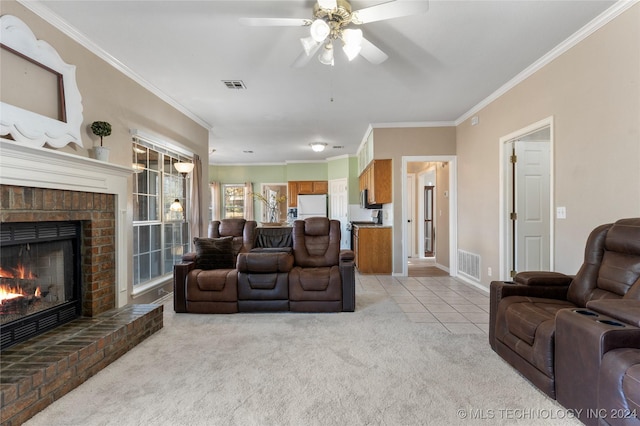 living room with a brick fireplace, ceiling fan, light colored carpet, and ornamental molding