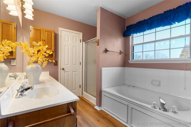 bathroom featuring hardwood / wood-style flooring, vanity, and plus walk in shower