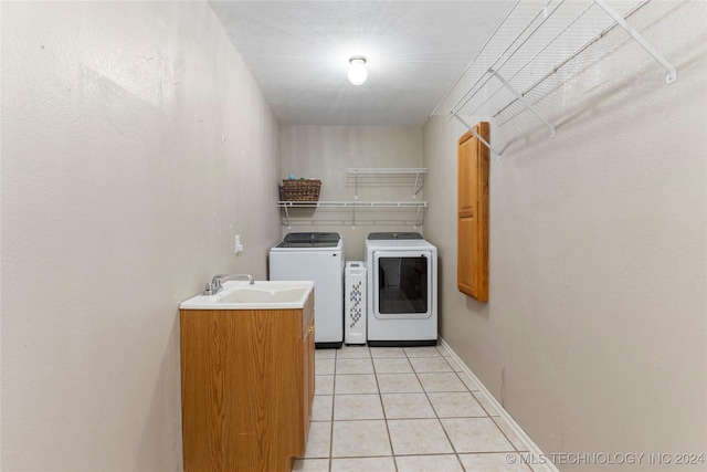 laundry area featuring light tile patterned flooring, separate washer and dryer, and sink