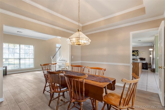 dining room with a raised ceiling, hardwood / wood-style flooring, an inviting chandelier, and ornamental molding