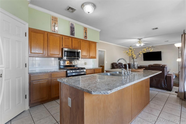 kitchen with sink, an island with sink, stainless steel appliances, and ornamental molding