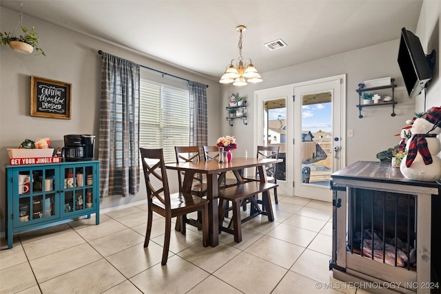 tiled dining room featuring an inviting chandelier