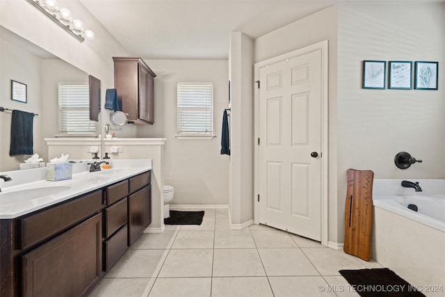 bathroom with toilet, vanity, tile patterned floors, and a healthy amount of sunlight