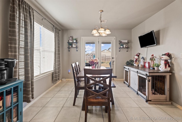 tiled dining area featuring an inviting chandelier