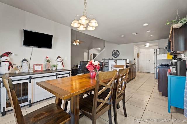 dining area with light tile patterned flooring and ceiling fan with notable chandelier