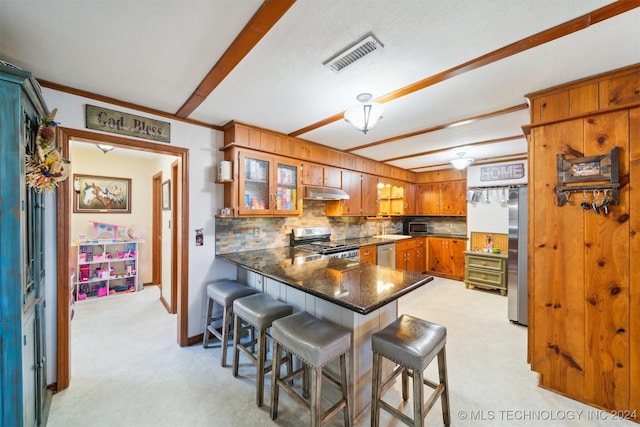 kitchen with a breakfast bar area, light carpet, appliances with stainless steel finishes, kitchen peninsula, and backsplash