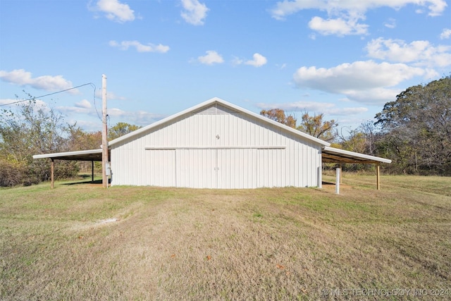 garage with a carport and a lawn