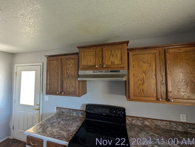 kitchen with electric range, a textured ceiling, and hardwood / wood-style flooring