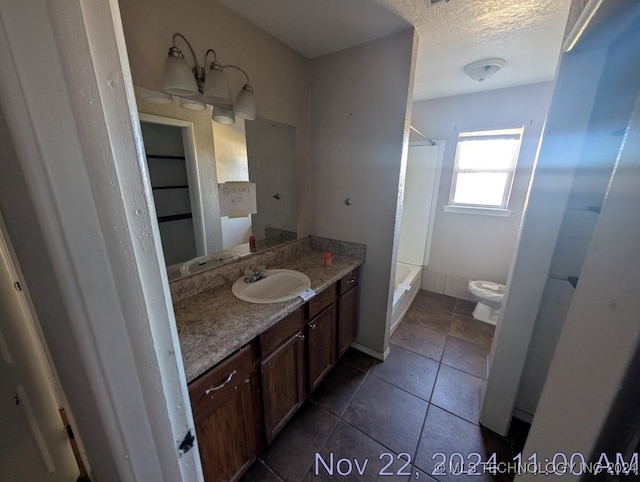 bathroom featuring tile patterned floors, vanity, a textured ceiling, a shower, and toilet