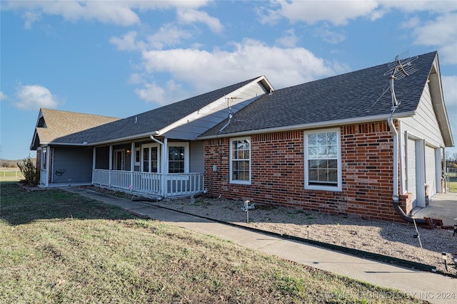 ranch-style house with a garage, a front yard, and a porch