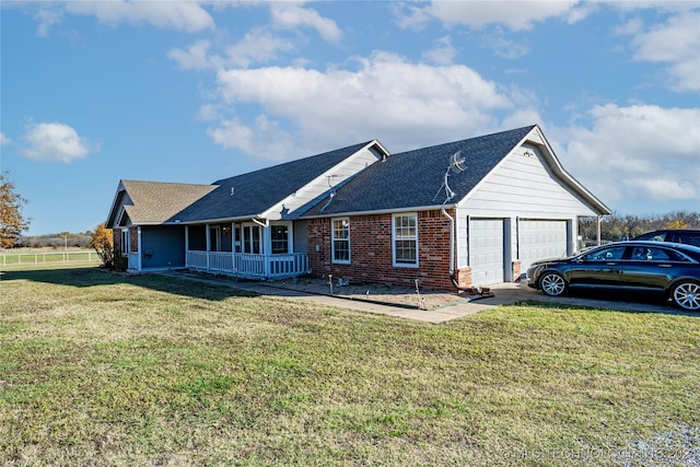 ranch-style home with a garage, covered porch, and a front yard