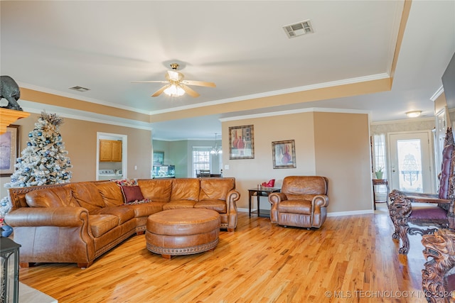 living room featuring washer / clothes dryer, ornamental molding, ceiling fan, and light hardwood / wood-style floors