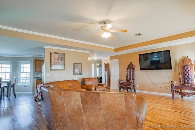 living room featuring hardwood / wood-style flooring, ornamental molding, and ceiling fan