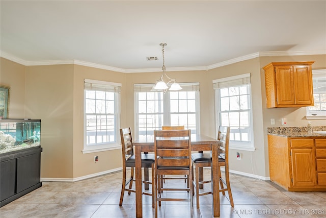 tiled dining area featuring crown molding and a wealth of natural light