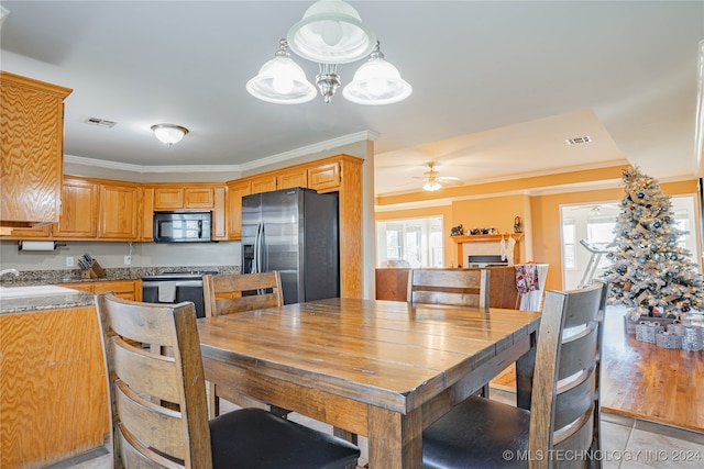 dining area with crown molding, sink, and ceiling fan with notable chandelier