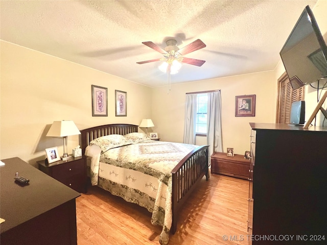 bedroom featuring a textured ceiling, light hardwood / wood-style floors, and ceiling fan