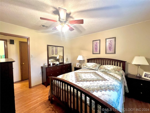 bedroom featuring ceiling fan, a textured ceiling, and light hardwood / wood-style flooring