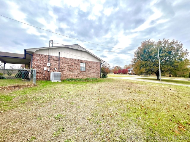 view of home's exterior with a lawn and central AC