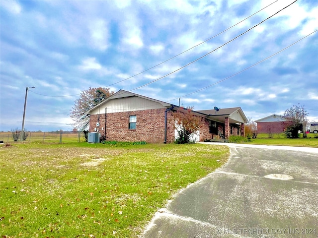 view of front of house featuring a front lawn and central AC unit