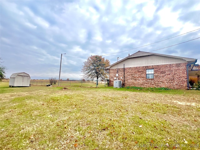 view of yard featuring cooling unit and a storage shed