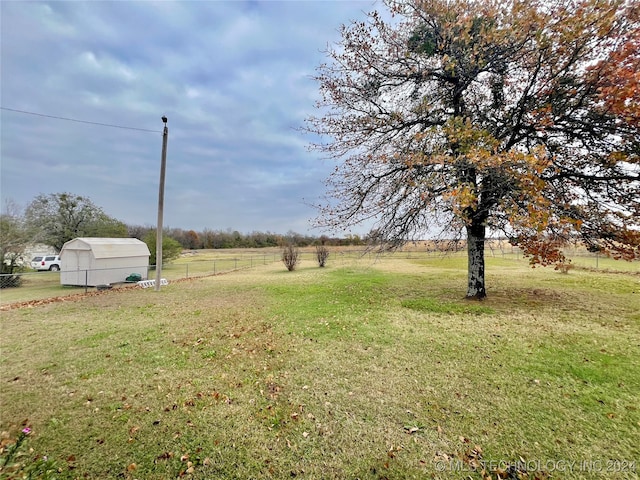 view of yard with a rural view and an outdoor structure