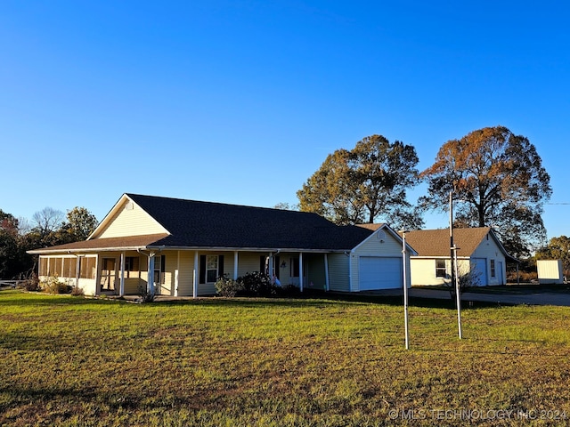 view of front of property with a porch, a garage, and a front lawn