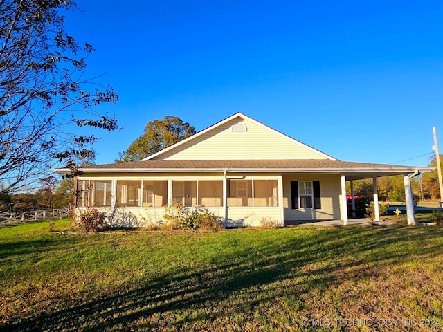 back of house with a sunroom and a lawn