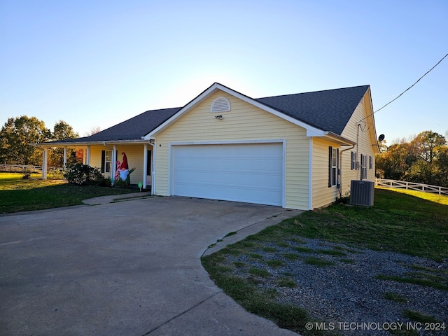 single story home featuring covered porch, a garage, a front yard, and central AC