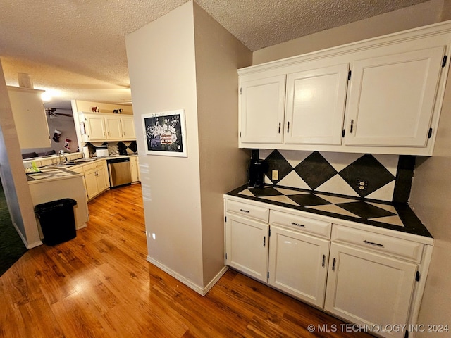 kitchen with dishwasher, white cabinetry, a textured ceiling, and light hardwood / wood-style flooring