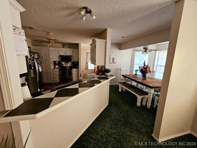 kitchen with stainless steel electric stove, kitchen peninsula, a wealth of natural light, and refrigerator with ice dispenser