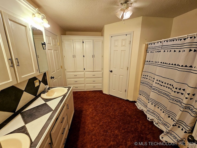 bathroom featuring a shower with curtain, ceiling fan, vanity, and a textured ceiling