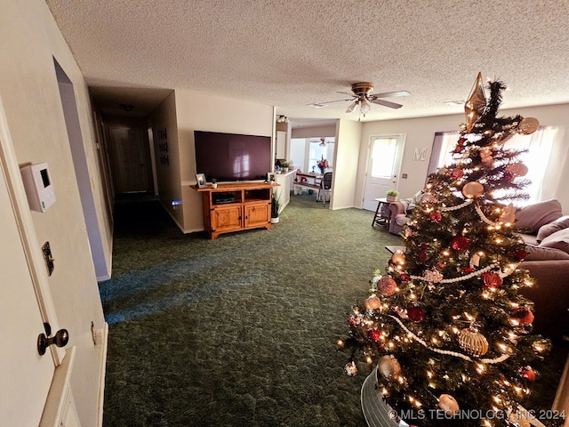 living room featuring ceiling fan, a textured ceiling, and dark colored carpet