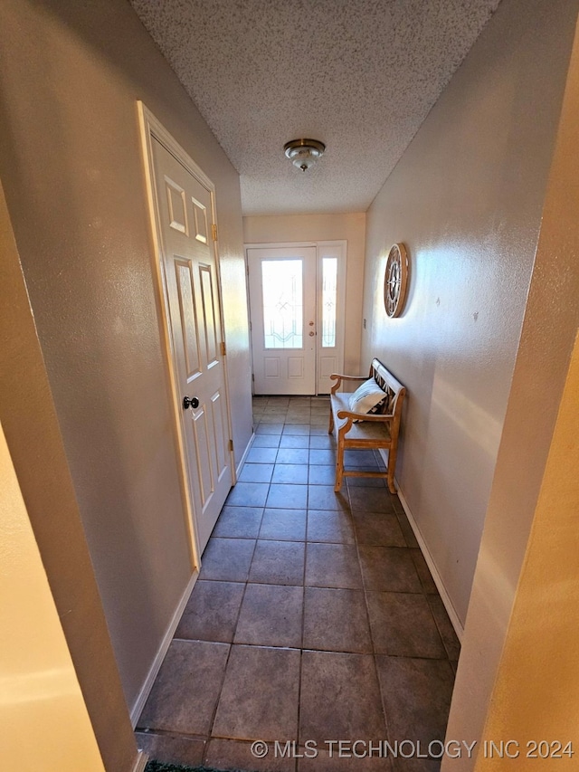 entryway featuring tile patterned floors and a textured ceiling