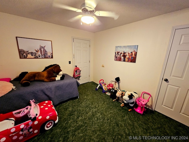 bedroom featuring a textured ceiling, dark carpet, and ceiling fan