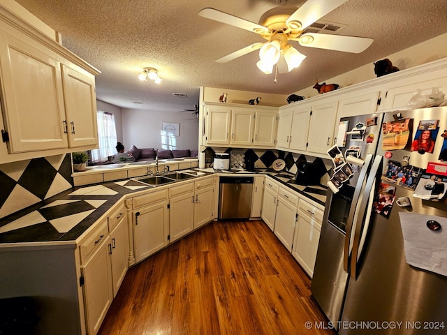 kitchen featuring appliances with stainless steel finishes, a textured ceiling, sink, tile countertops, and dark hardwood / wood-style floors