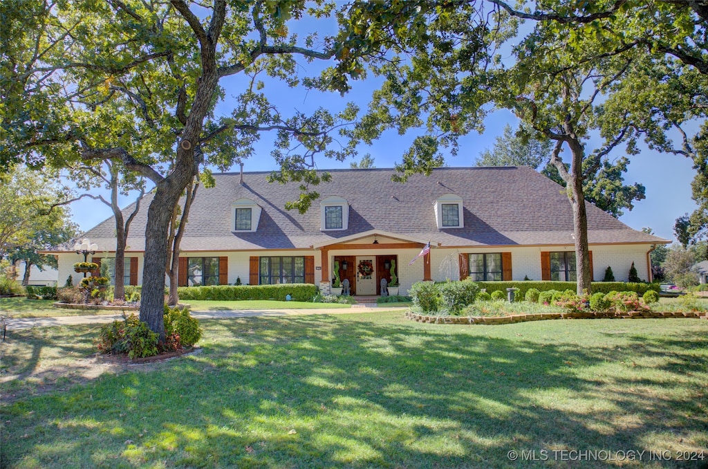 cape cod house with a front yard