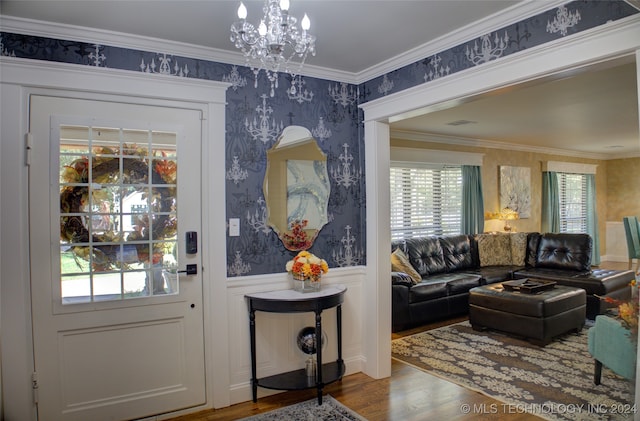 interior space with hardwood / wood-style floors, an inviting chandelier, and ornamental molding