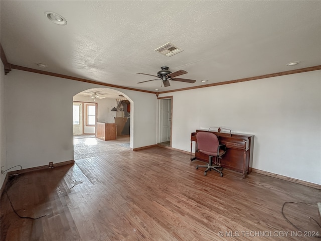 unfurnished office with wood-type flooring, a textured ceiling, ceiling fan, and crown molding