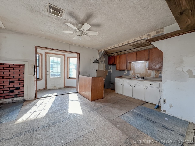 kitchen featuring white cabinets, a textured ceiling, ceiling fan, and sink