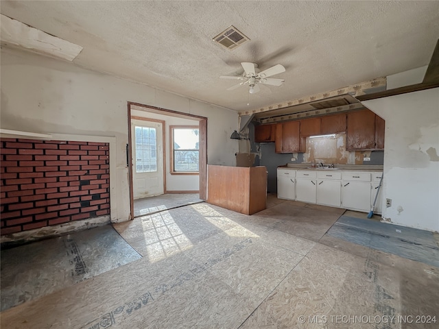 kitchen featuring ceiling fan, sink, and a textured ceiling