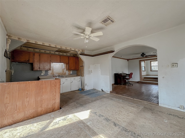 kitchen featuring ceiling fan, wood-type flooring, and a textured ceiling