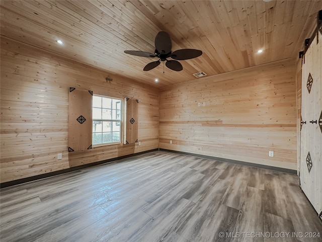 spare room with wood walls, wood-type flooring, and wooden ceiling