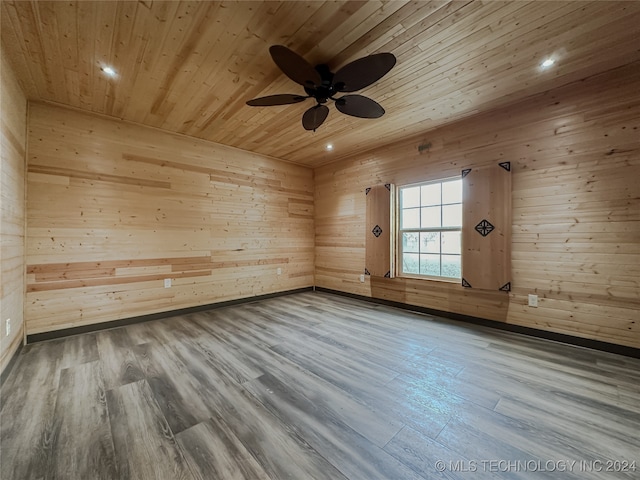 unfurnished room featuring hardwood / wood-style flooring, wood ceiling, and wooden walls