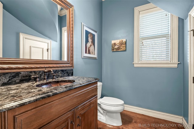 bathroom with hardwood / wood-style flooring, vanity, and toilet