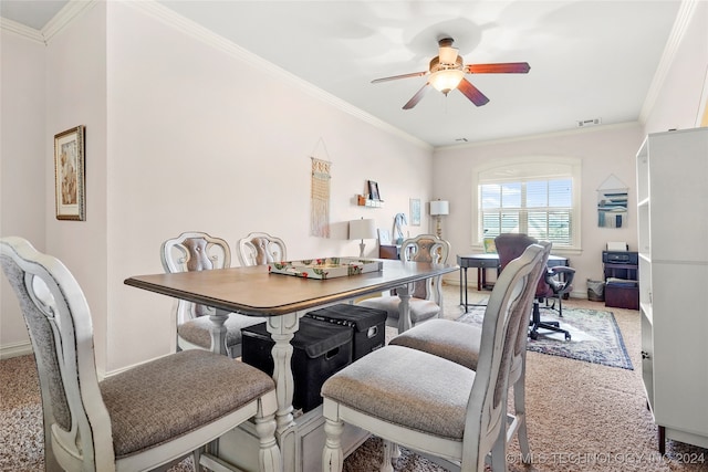 dining area with ceiling fan, crown molding, and light carpet