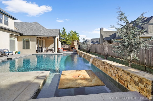 view of swimming pool featuring pool water feature and a patio