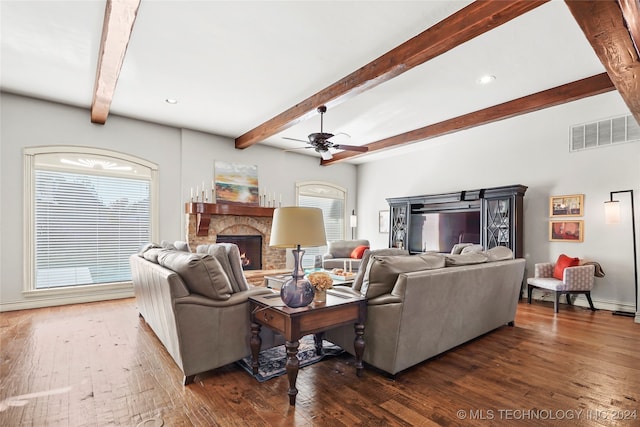 living room with a wealth of natural light, dark hardwood / wood-style flooring, and beamed ceiling